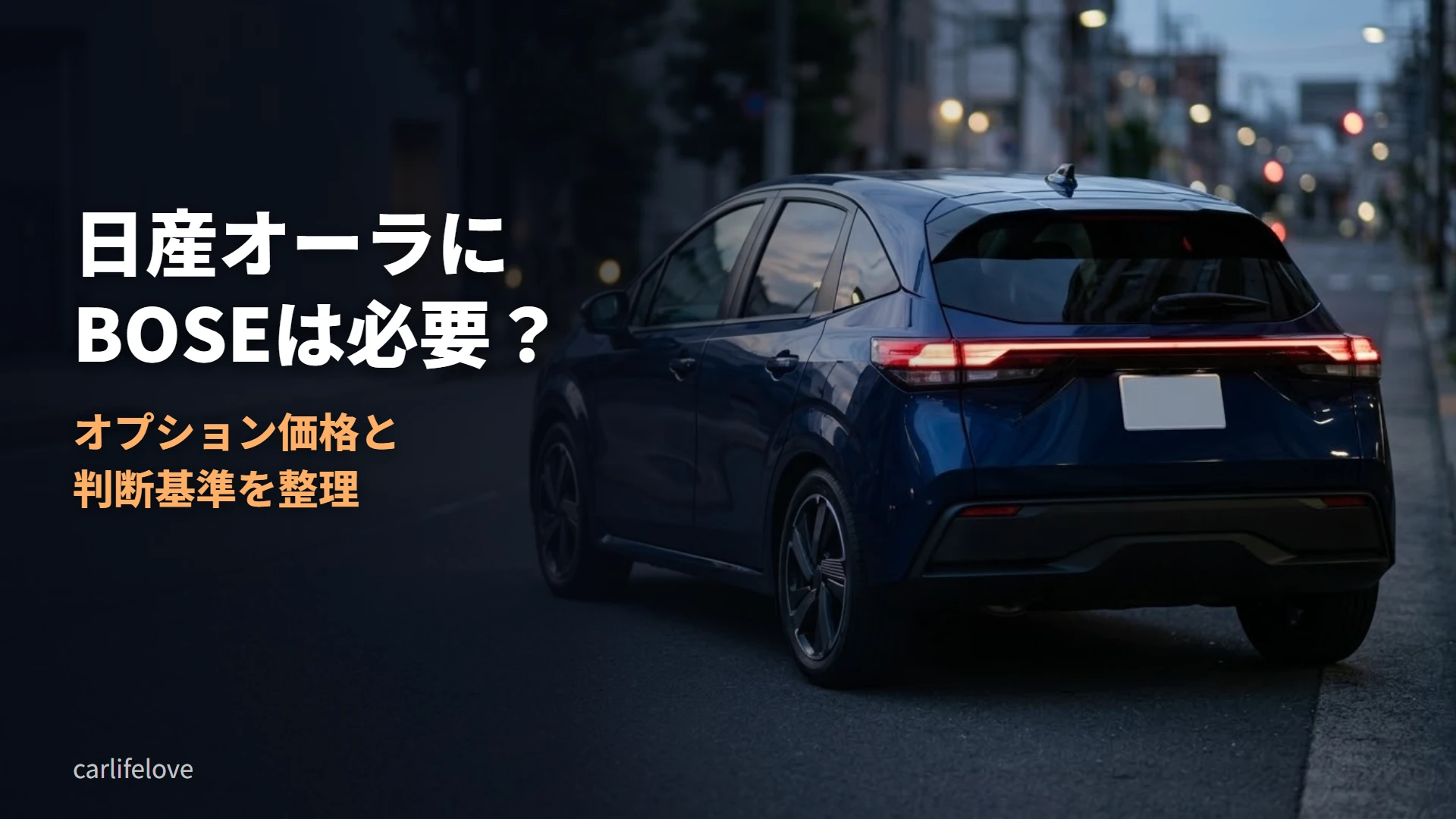 夕暮れの街路に停まる紺色のコンパクトカーの後ろ姿